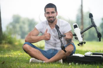 Portrait of Confident Young Engineer With Remote Control and Drone Gives Thumbs Up