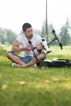 Young Engineer Man Prepares a Drone to Flight in Park