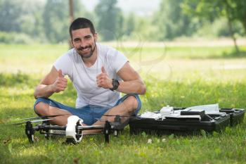 Portrait of Confident Young Engineer With Remote Control and Drone Gives Thumbs Up