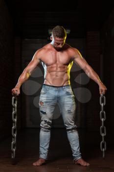 Healthy Young Bodybuilder Exercising Biceps With Chains