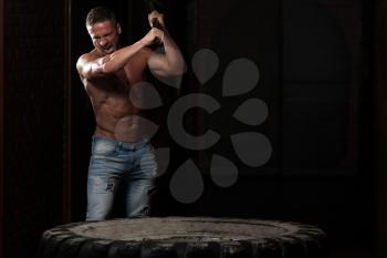Athletic Man In Pants Hits Tire - Workout At Gym With Hammer And Tractor Tire