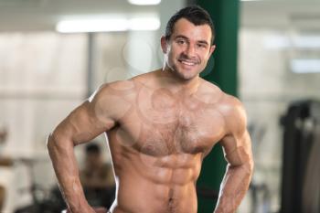 Hairy Healthy Young Man Standing Strong In The Gym And Flexing Muscles - Muscular Athletic Bodybuilder Fitness Model Posing After Exercises