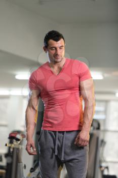 Handsome Young Man Standing Strong in Pink T-shirt and Flexing Muscles - Muscular Athletic Bodybuilder Fitness Model Posing After Exercises