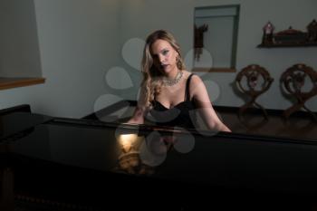 Piano Playing Pianist Concert - Classical Music Musician Player With Grand Piano in Darkness