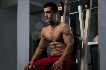 Resting Time - Confident Muscled Young Man Resting In Healthy Club Gym After Exercising