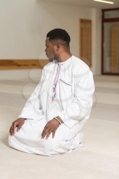 African Muslim Man Making Traditional Prayer To God While Wearing A Traditional Cap Dishdasha