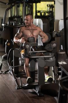 Handsome Bodybuilder Doing Heavy Weight Exercise For Back On Machine