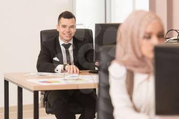Happy Young Business Man And Muslim Woman Work In Modern Office On Computer
