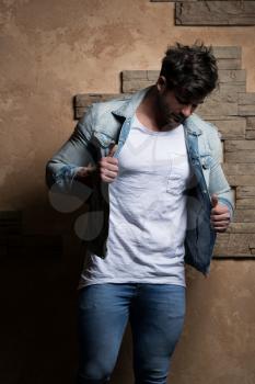 Portrait of Handsome Bearded Man Dressed in Fashionable Clothes Standing Against Wall Background With Area for Advertising Content - Hipster Guy Posing on Copy Space