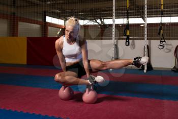 Young Woman Working Out With Kettle Bell In A Dark Gym - Fitness Doing Heavy Weight Exercise With Kettle-bell