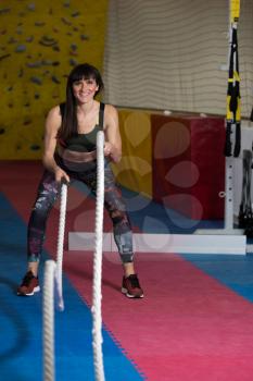 Battling Ropes Young Woman At Gym Workout Exercise