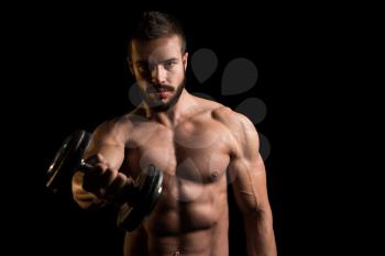 Young Man Working Out Shoulders With Dumbbells On Black Background