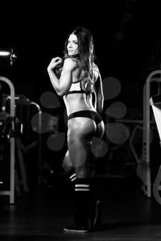 Healthy Young Woman Standing Strong In The Gym And Flexing Muscles - Beautiful Athletic Fitness Model Posing After Exercises