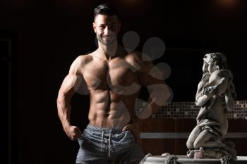 Healthy Young Man Standing Strong In Hot Sauna And Flexing Muscles - Muscular Athletic Bodybuilder Fitness Model Posing After Exercises