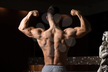 Healthy Young Man Standing Strong In Hot Sauna And Flexing Muscles - Muscular Athletic Bodybuilder Fitness Model Posing After Exercises