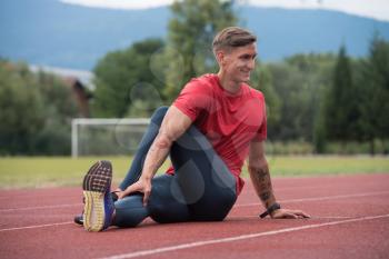 Portrait of Fit and Sporty Young Man Doing Stretching in the Park