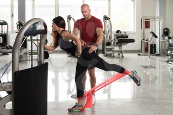 Couple Athlete in Sport Sportswear Workout With Elastic Resistance Band - Doing Legs Exercises in Gym