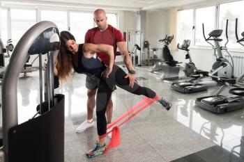 Couple Athlete in Sport Sportswear Workout With Elastic Resistance Band - Doing Legs Exercises in Gym