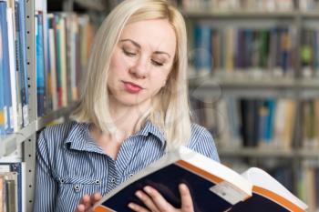 Pretty Female Student With Books Working in a High School Library