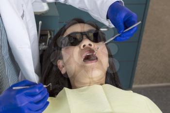Horizontal photo of a male dentist working on mature woman patient