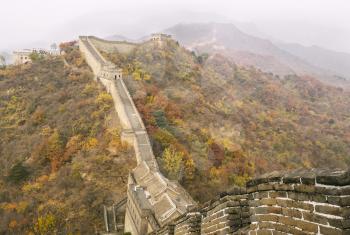 The Great Wall of China during the Autumn Season with mountains and sky in background