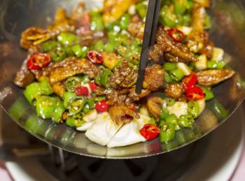 Spicy hot Chinese dish made in China with chop sticks in pan