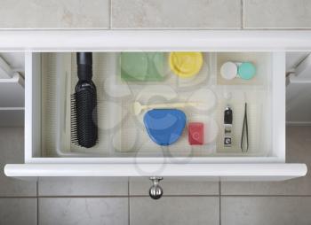 Open bathroom drawer with personal hygiene accessories displayed