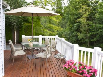 Outdoor patio setup on cedar wood deck  with trees in background