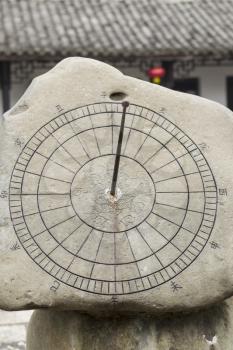 ancient sun dial to keep track of time in China with temple in background