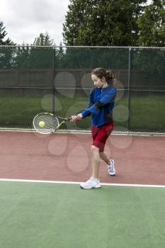 Young girl using a two handed backhand for lefthand tennis Player