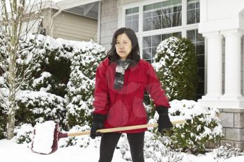 Women working outside cleaning snow in front of house