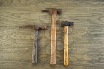 Horizontal photo of old masonry, claw and ball peen hammers on aged wood