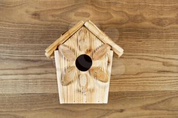 Overhead view of new wooden birdhouse on rustic wood