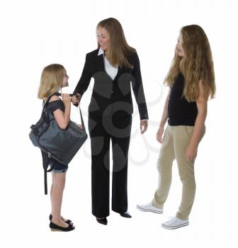 Side view of businesswoman and her young daughters greeting her as she comes home from work isolated on a white background 