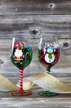 Vertical image of holiday drinking glasses, filled with drink, on rustic wood 