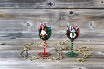 Horizontal image of holiday drinking glasses, filled with drink, on rustic wood 