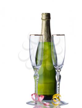 Empty tall elegant drinking glasses with unopened bottle of sparkling wine isolated over white background with reflection and party ribbons 