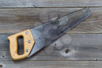 Used Hand saw on rustic wooden boards