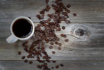 Top view image of fresh dark coffee and premium roasted whole beans on rustic wood with slight vignette border
