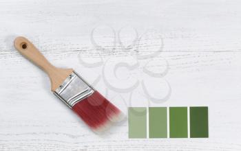 New paint brush and paint color choice template on white wooden boards with plenty of copy space 