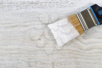 Wet paint brush on old white wooden boards