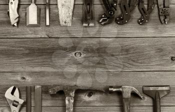 Vintage concept of used partial tools forming border on rustic wooden boards. 