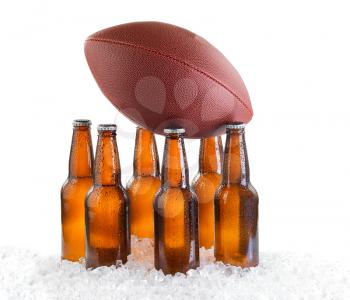 Six pack of bottled beer holding up American Football isolated on white background