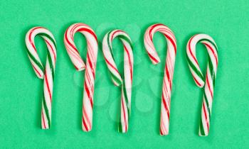 Difficult color candy cane collection on green background. 