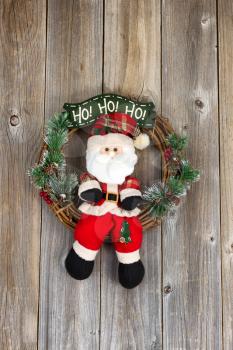 Wreath with Santa Claus symbol on rustic wood. Layout in vertical format. 