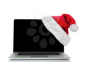 Traditional Christmas Santa Cap and laptop computer isolated on white background with reflection. 