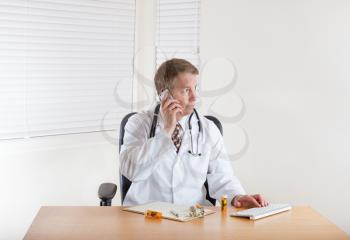 Doctor on phone while working in office 