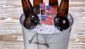 Miniature USA flags in bucket of ice with bottled beer. Fourth of July holiday concept for United States of America.  