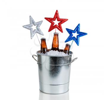 Colorful stars in bucket of ice with bottled beer. Isolated on white with reflection. Fourth of July holiday concept for United States of America.  