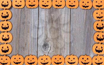 Halloween pumpkins forming complete border on rustic wood. 